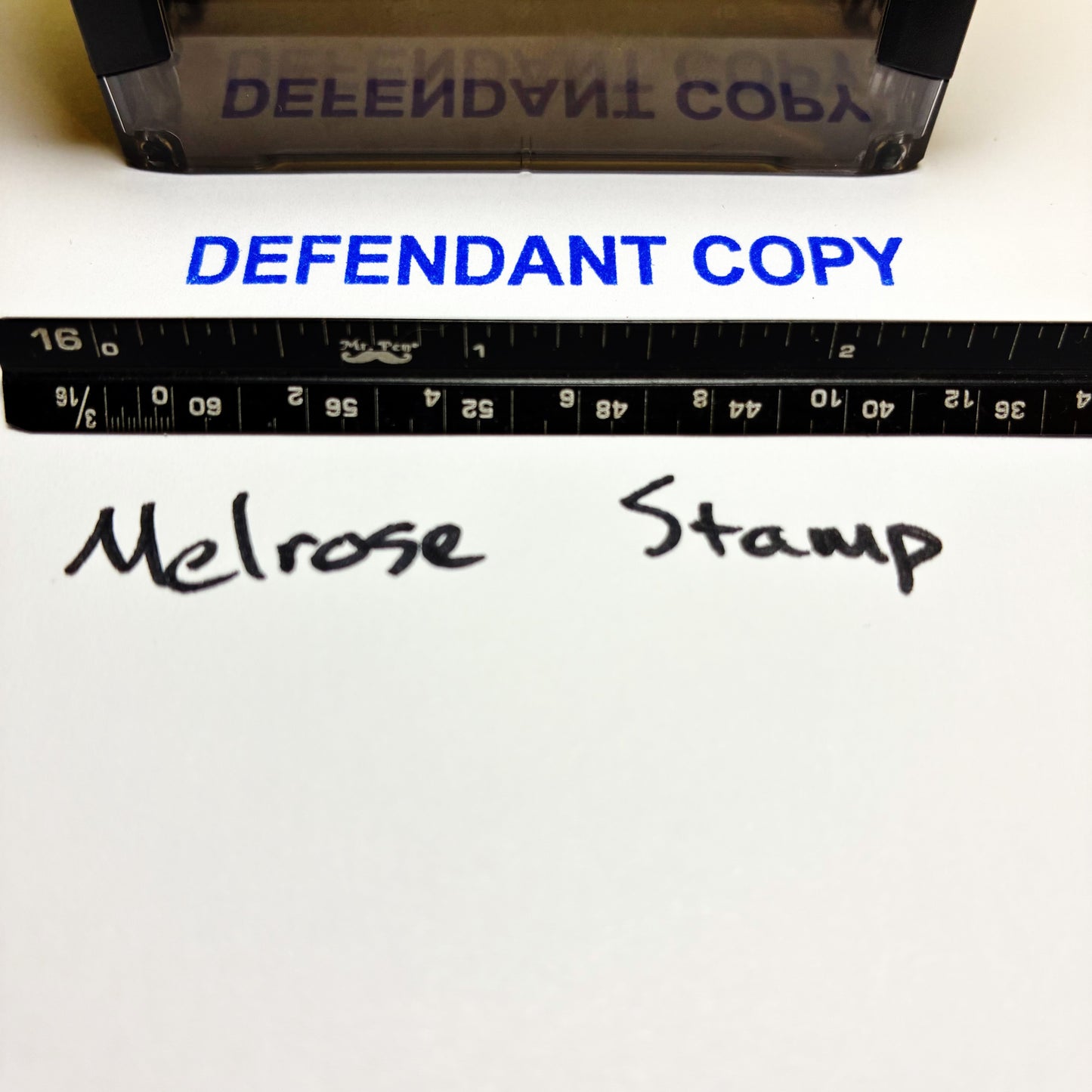 Stamp with 'DEFENDANT COPY' text and a ruler below, on a white background.