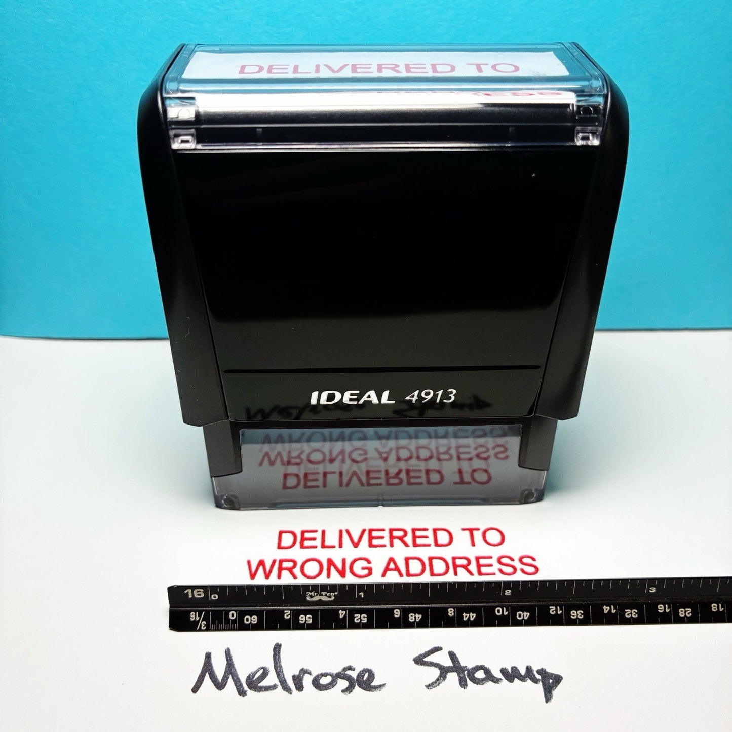 Self-inking stamp with 'Delivered to Wrong Address' text on a blue and white background