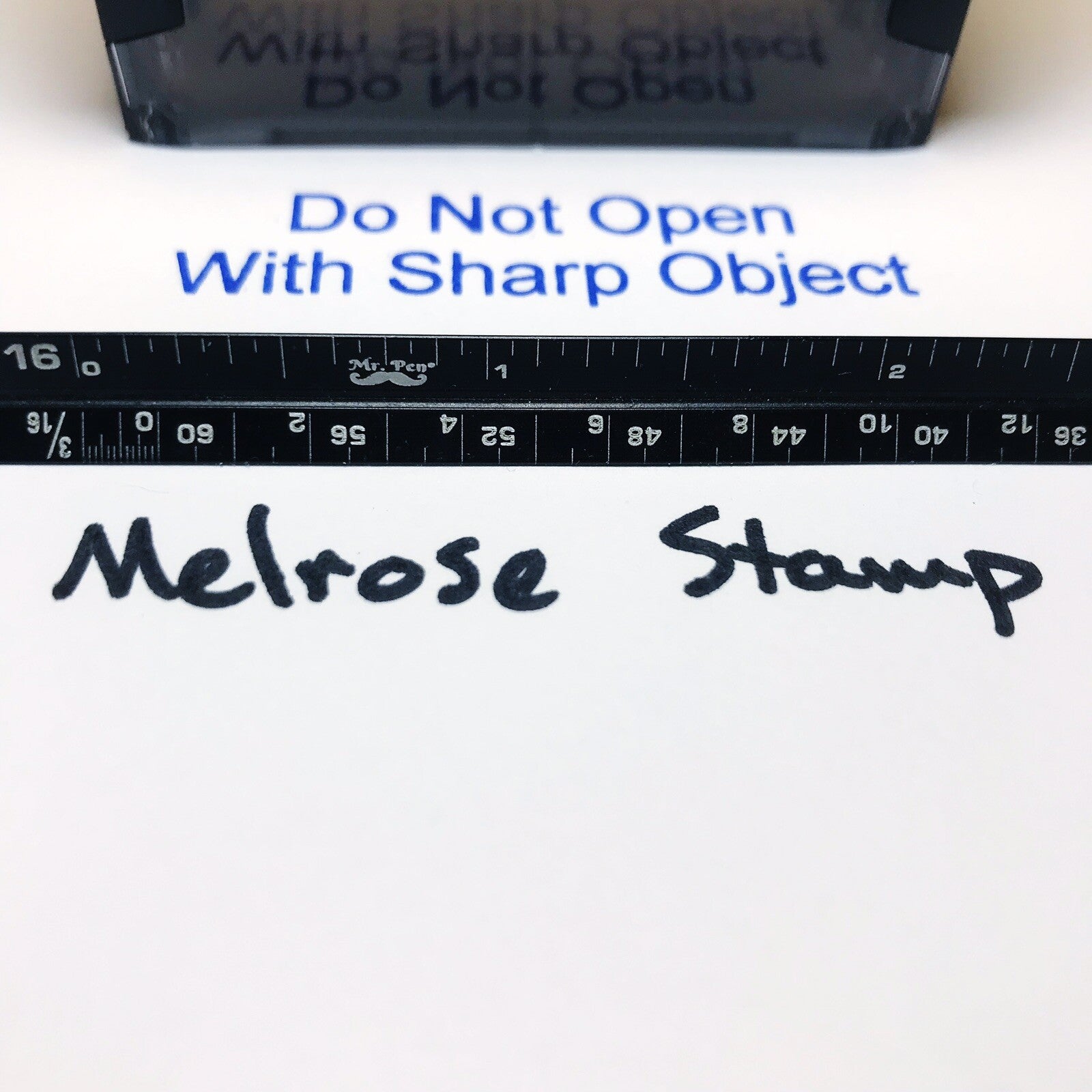 Melrose stamp with text 'Do Not Open With Sharp Object' and a ruler below.