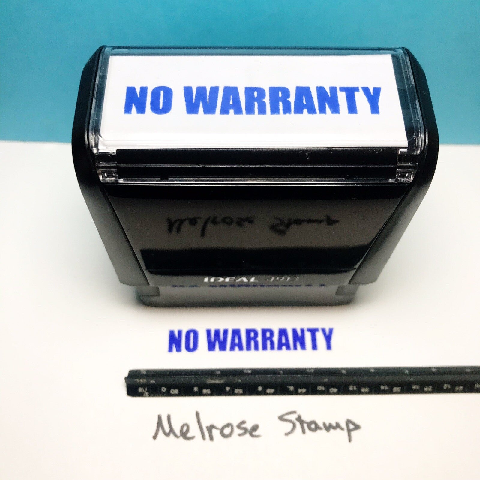 Black stamp with 'NO WARRANTY' text on a white surface and blue background