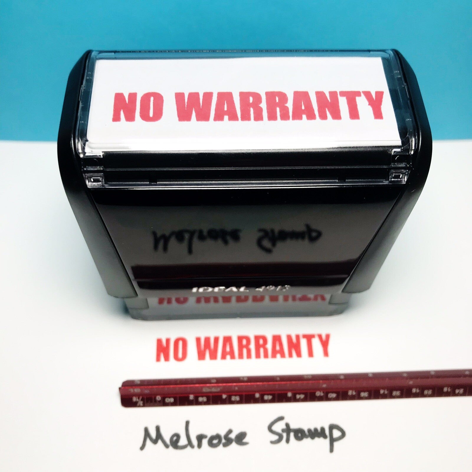 Rubber stamp with 'NO WARRANTY' text on a white surface with blue background