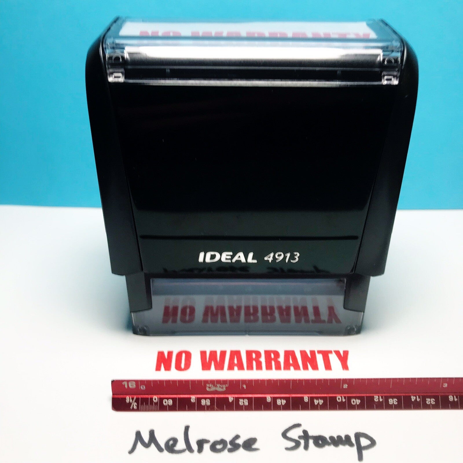 Rubber stamp with 'NO WARRANTY' text on a blue and white background, accompanied by a ruler for scale.