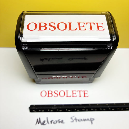Rubber stamp with 'OBSELETE' text red ink on a white surface and yellow background