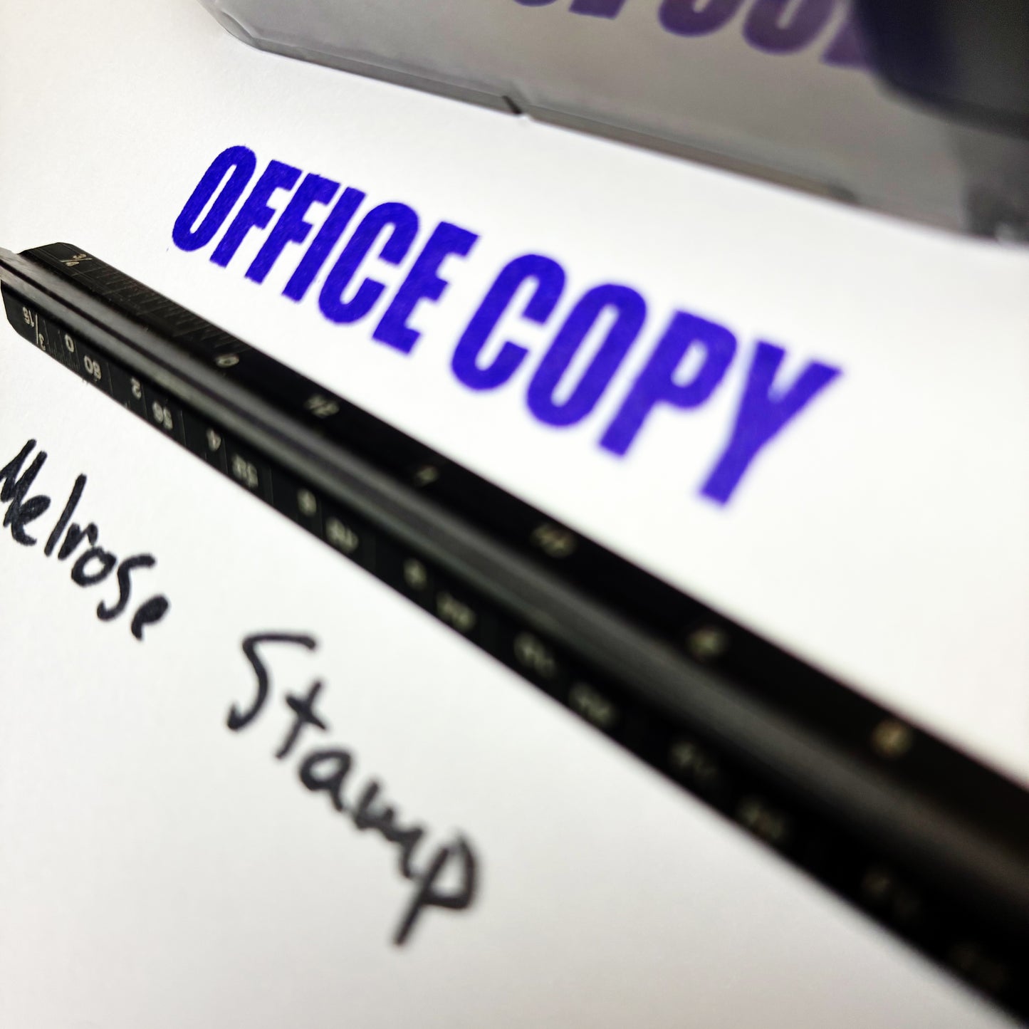 Close-up of a document with 'OFFICE COPY' printed on it, featuring a stamp and pen.