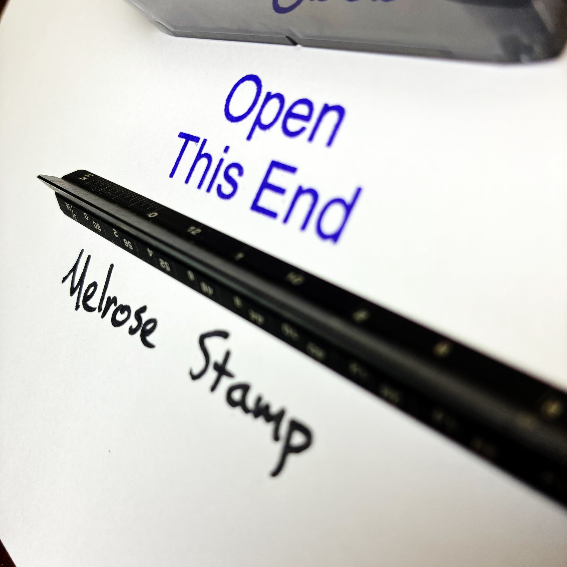 Close-up of a Melrose Stamp with text instructions on a white background