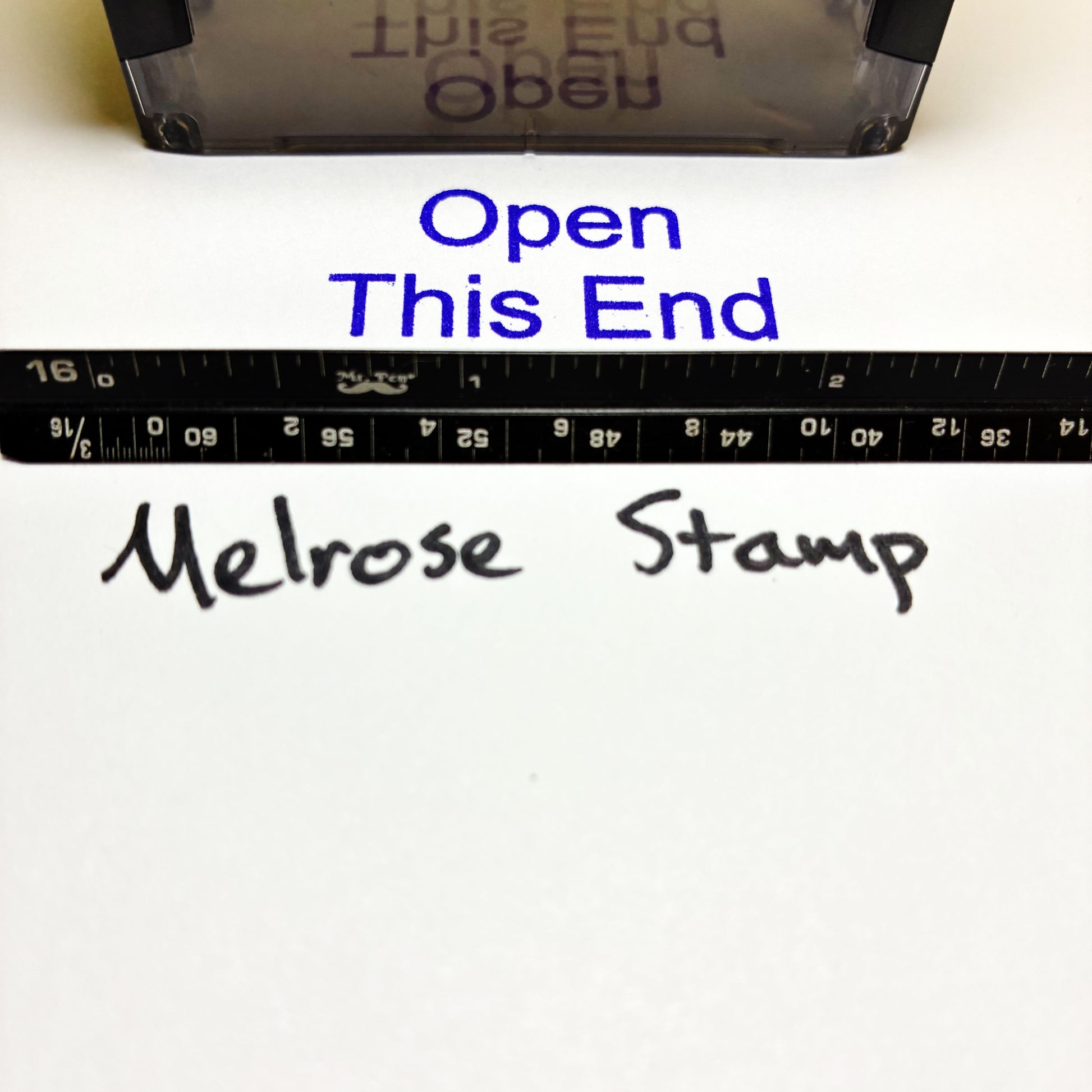 Melrose Stamp packaging with text 'Open This End' and a ruler for scale.