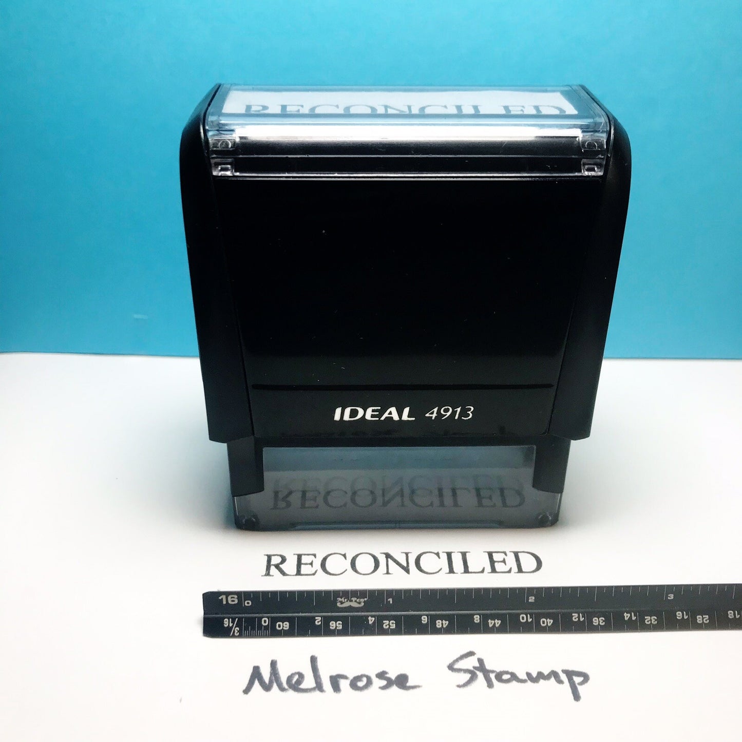 'RECONCILED' stamp text on a white surface against a blue background.