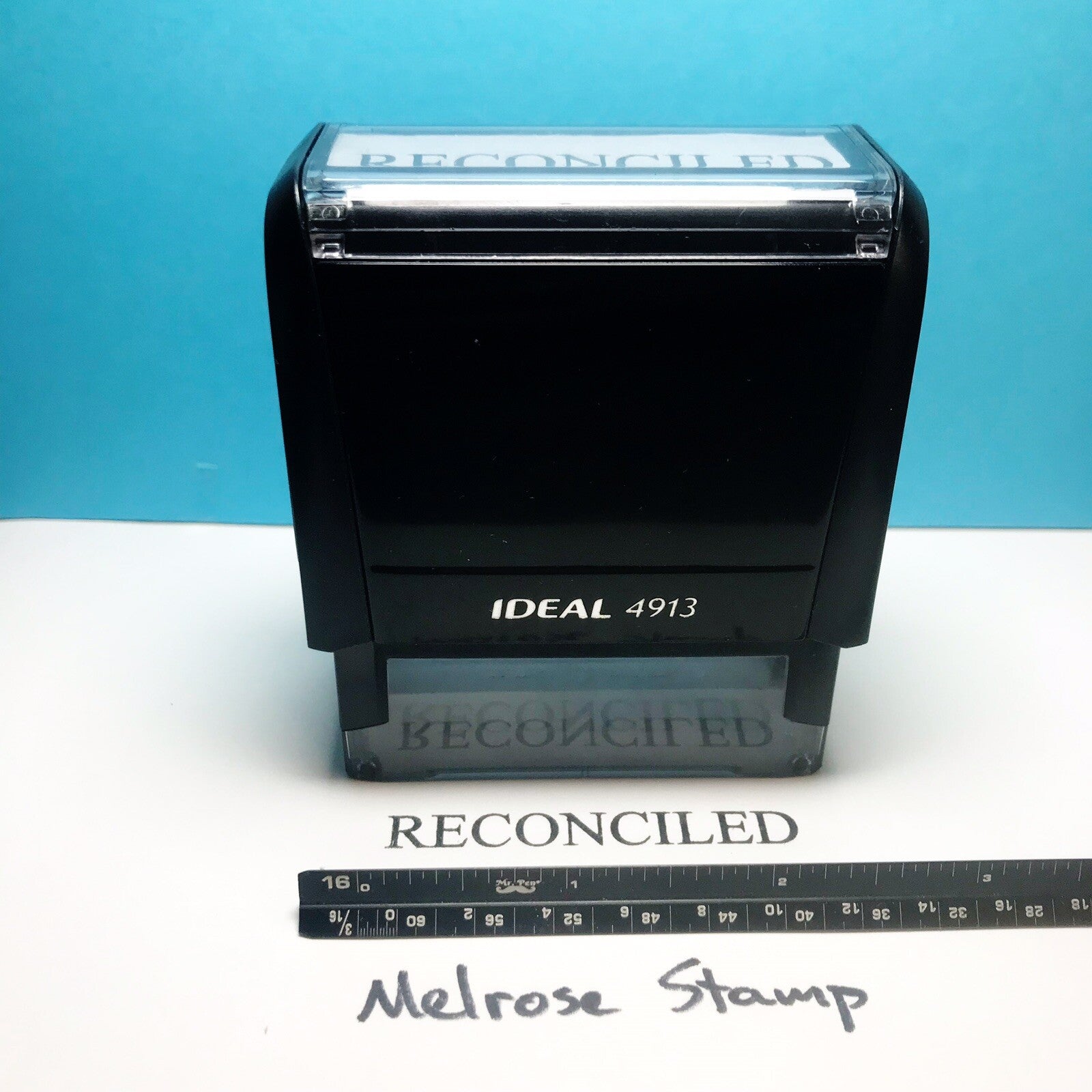 'RECONCILED' stamp text on a white surface against a blue background.