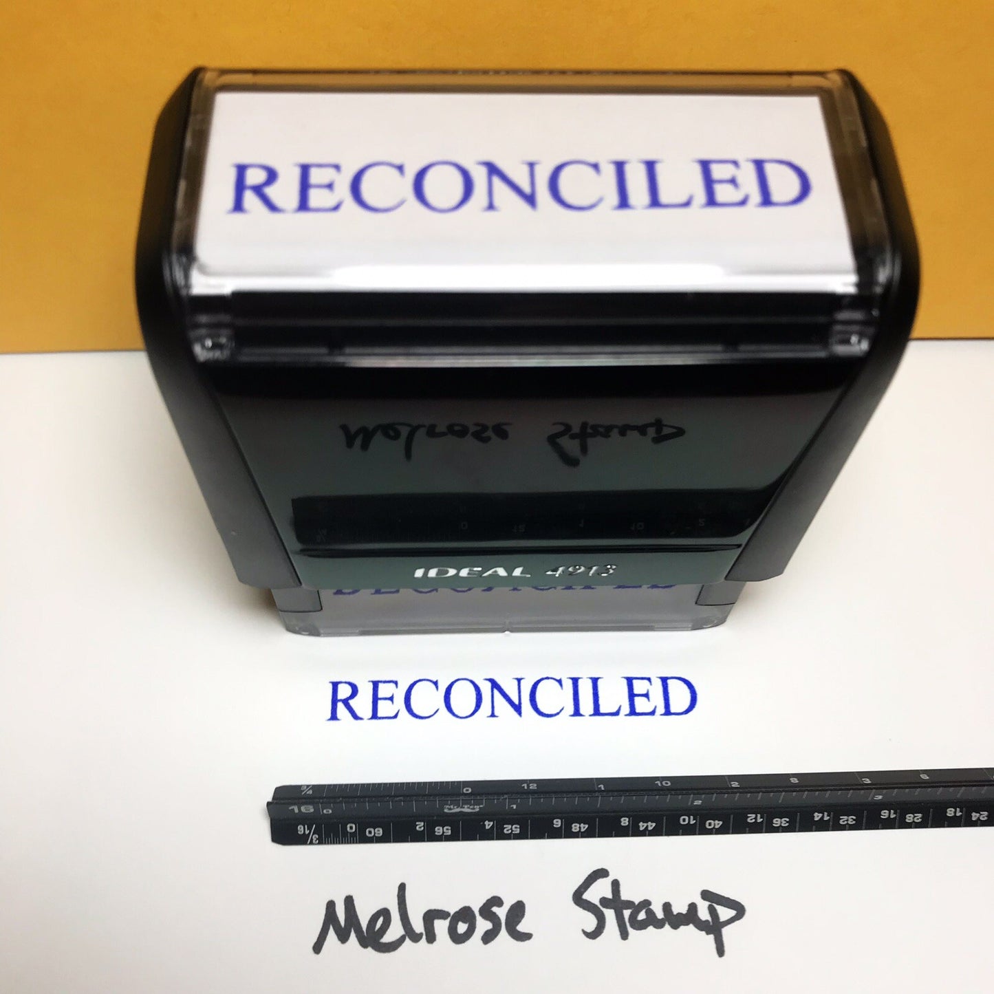 Self-inking rubber stamp with 'RECONCILED' text and Melrose Stamp branding.
