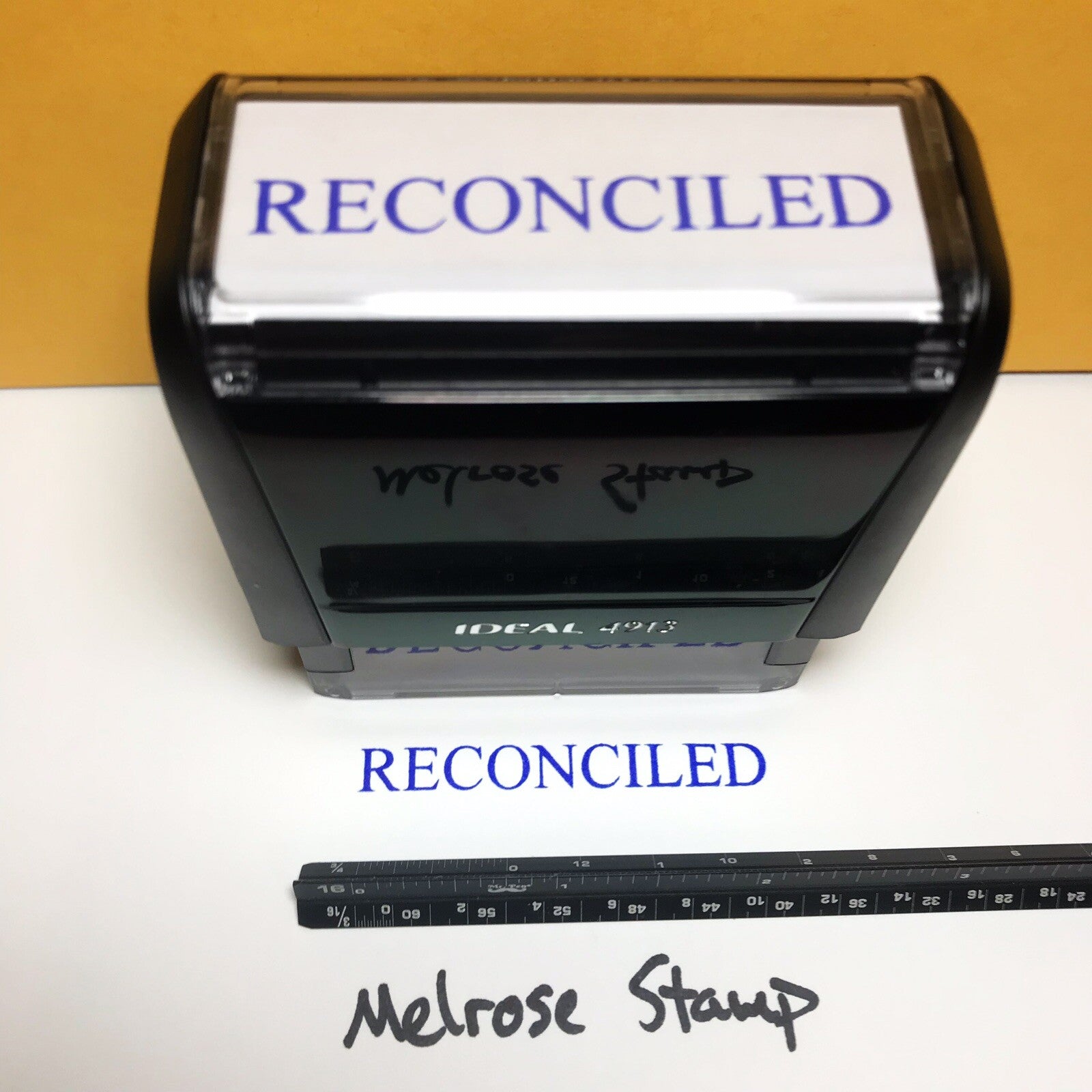 Self-inking rubber stamp with 'RECONCILED' text and Melrose Stamp branding.