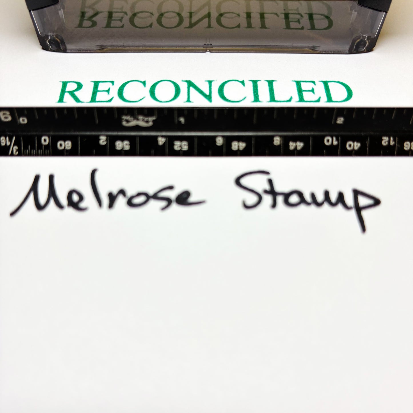 Clear stamp with 'RECONCILED' text and a ruler below, on a white background.