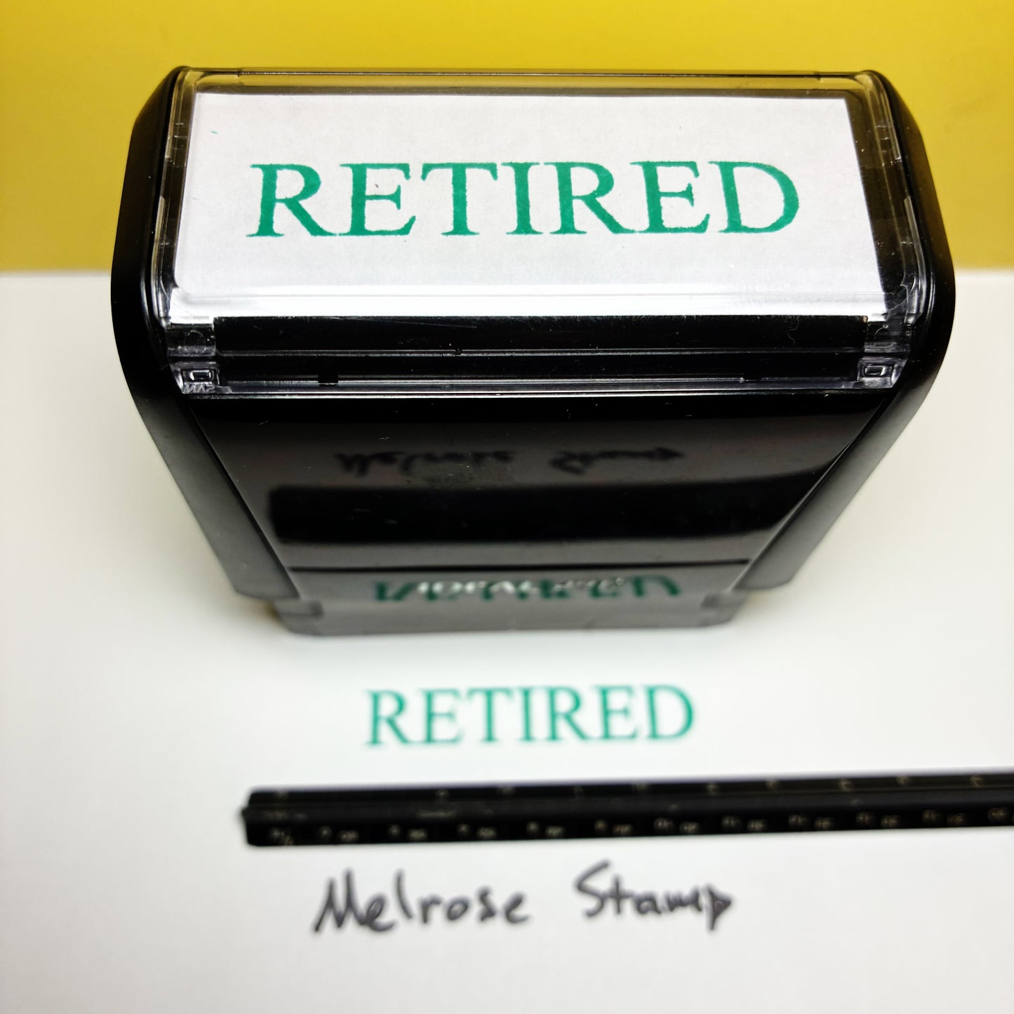 Retired stamp with a ruler for size reference on a white background