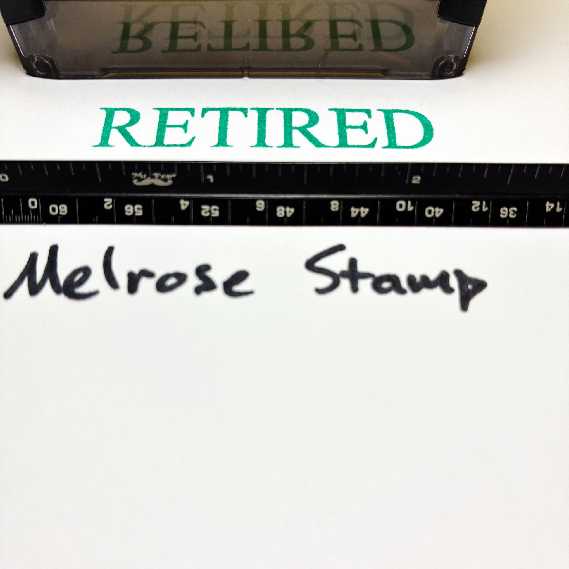 Text 'RETIRED' in green above 'Melrose Stamp' text on a white background with a ruler at the bottom.