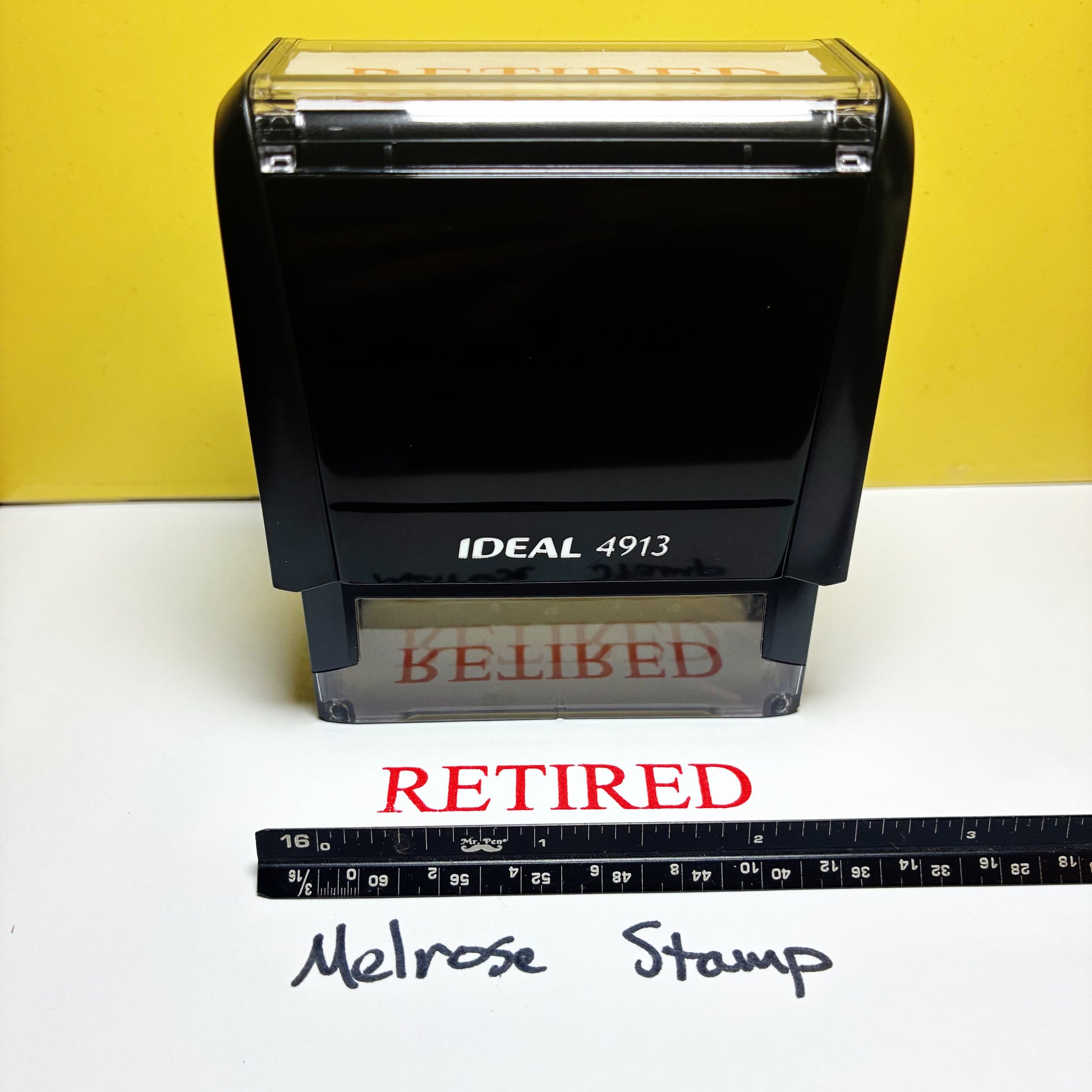 Rubber stamp IDEAL 4913 Retired stamper on a white surface with a yellow background