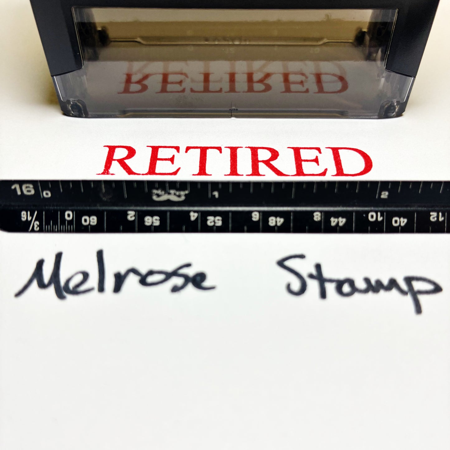Rubber stamp and a ruler below showing 'RETIRED' text, with 'Melrose Stamp' branding.