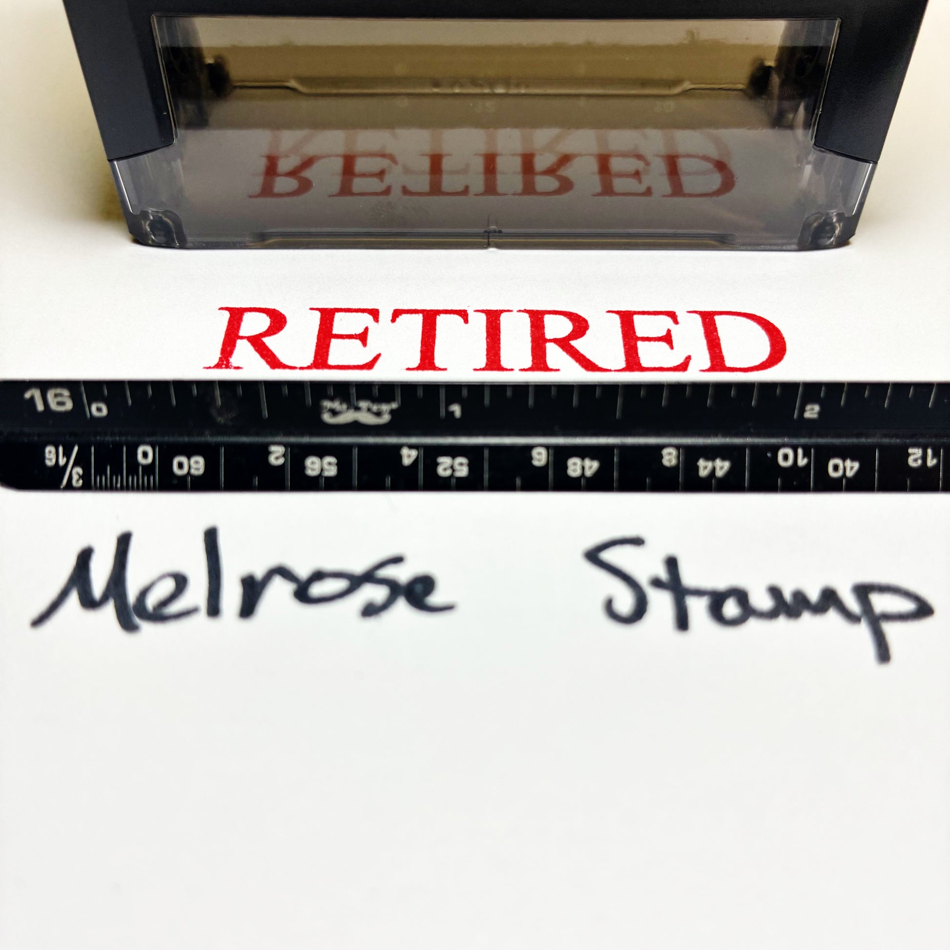 Rubber stamp and a ruler below showing 'RETIRED' text, with 'Melrose Stamp' branding.