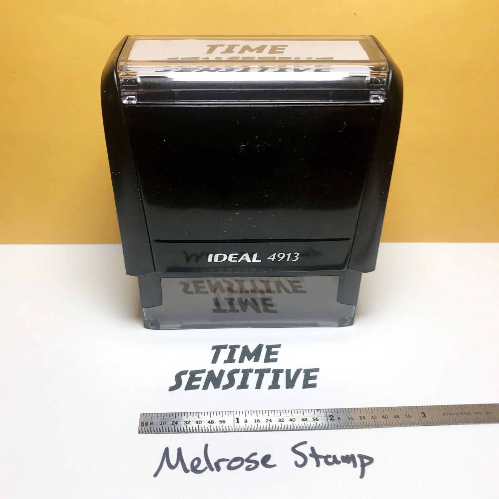 Black stamp with 'TIME SENSITIVE' text on a white surface with a yellow background
