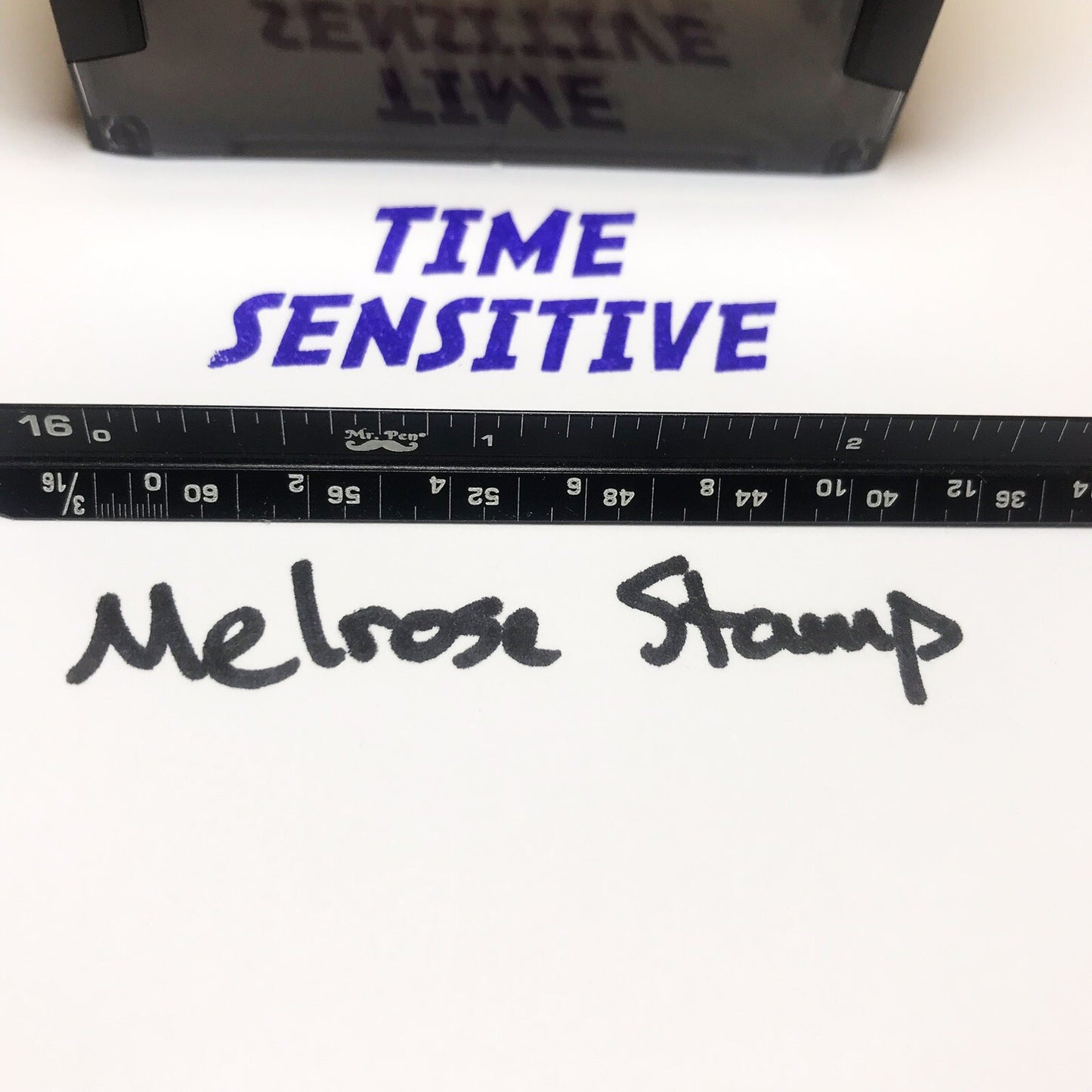 Stamp with 'TIME SENSITIVE' text and a ruler below on a white background
