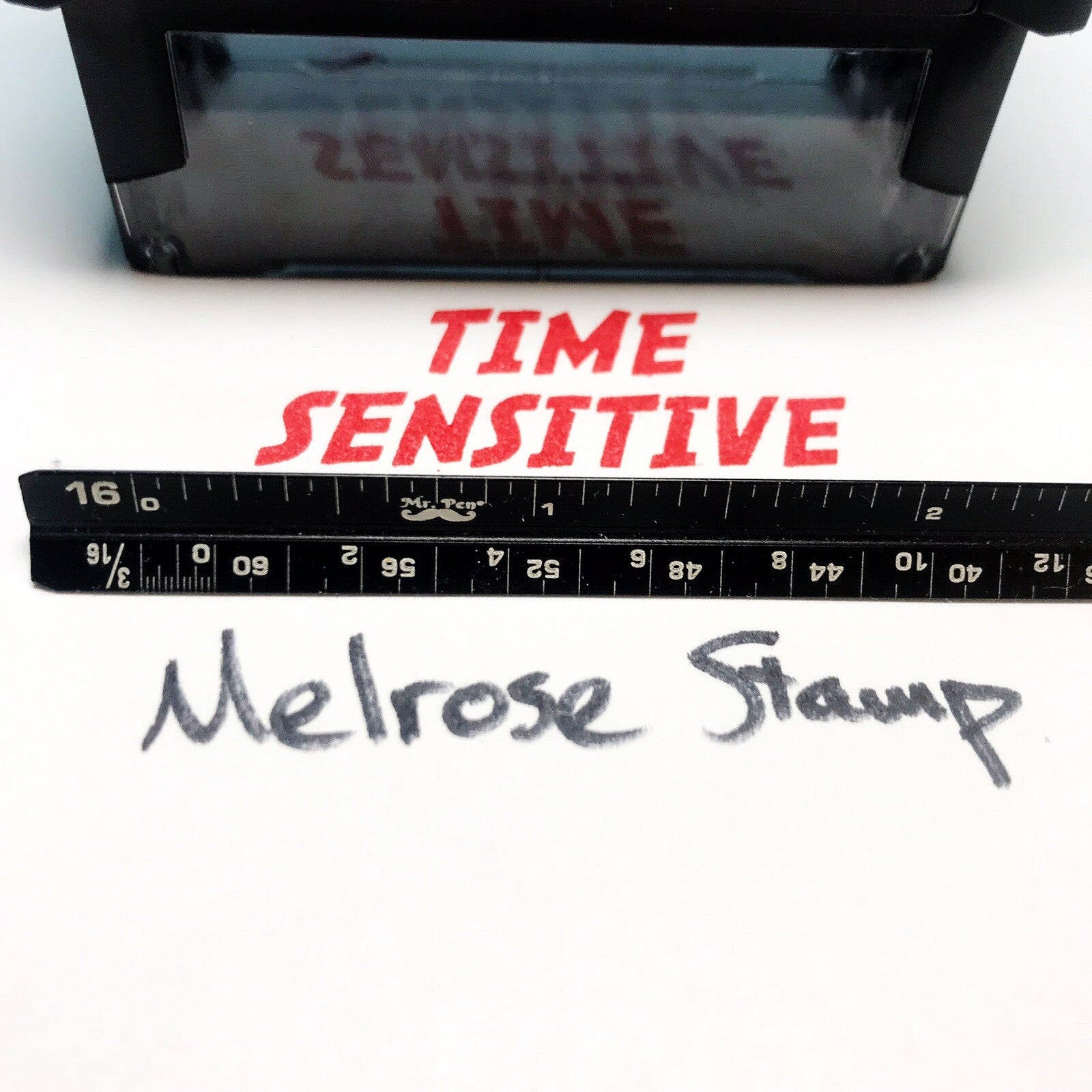 Stamp with 'Time Sensitive' text and a ruler below, on a white background.