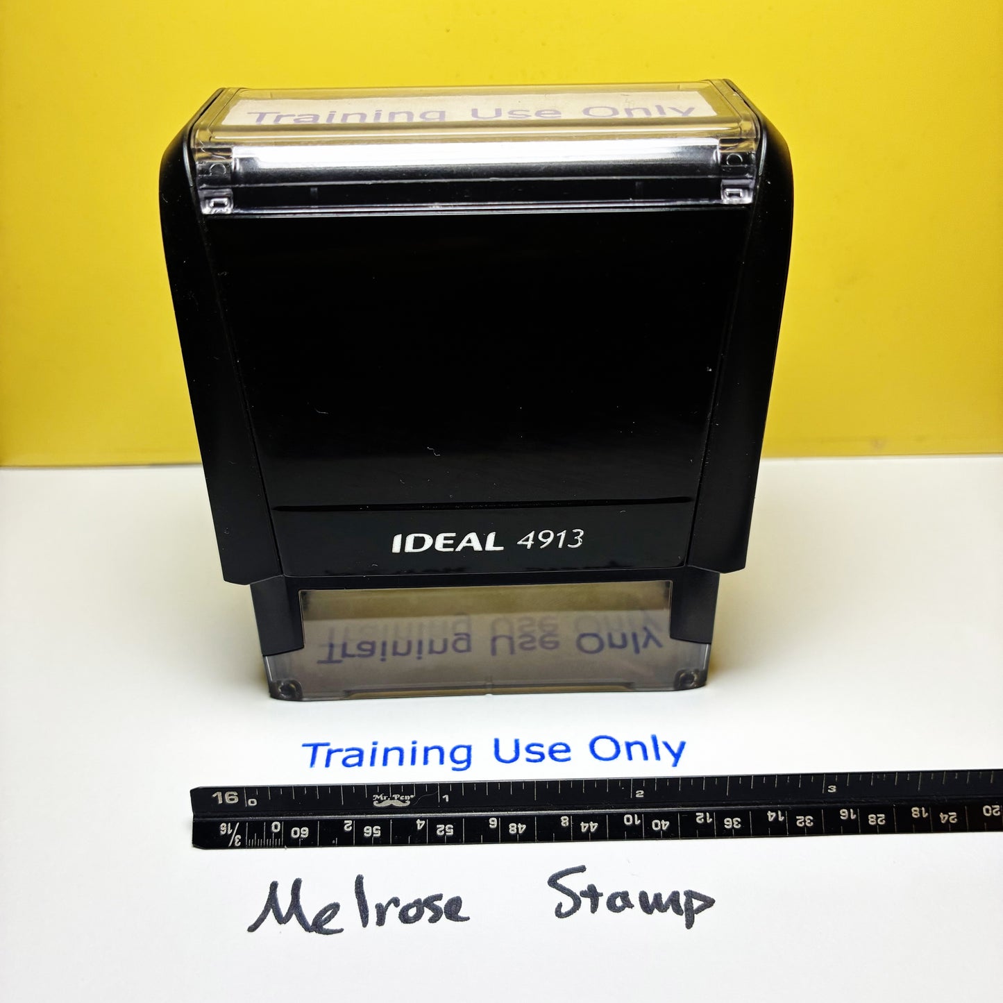 Rubber stamp with 'Training Use Only' text on a white surface with a yellow background