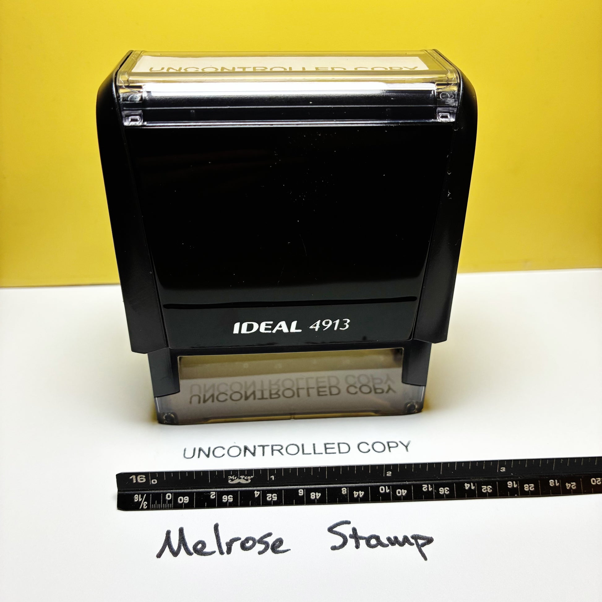 Uncontrolled Copy rubber stamp black ink large on a white paper with a yellow background