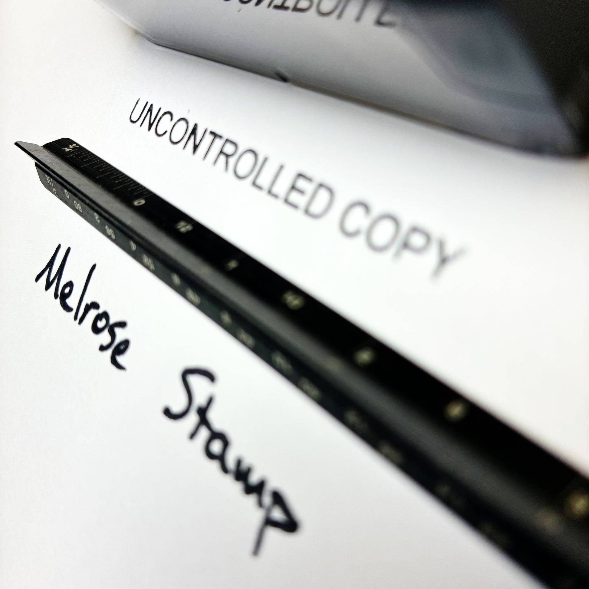 Close-up of a document with 'Melrose Stamp' and 'Uncontrolled Copy' text.