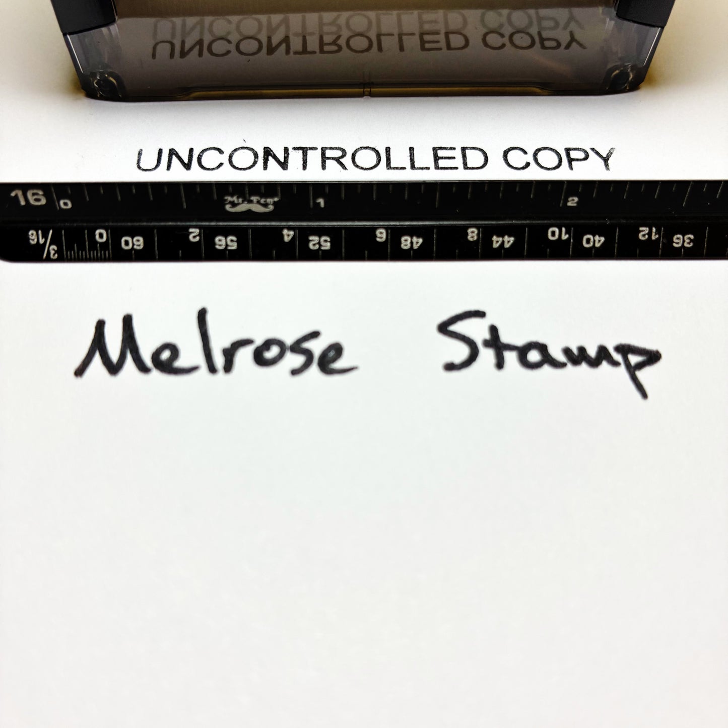 Text 'UNCONTROLLED COPY' printed on paper with a ruler and text 'Melrose Stamp'.