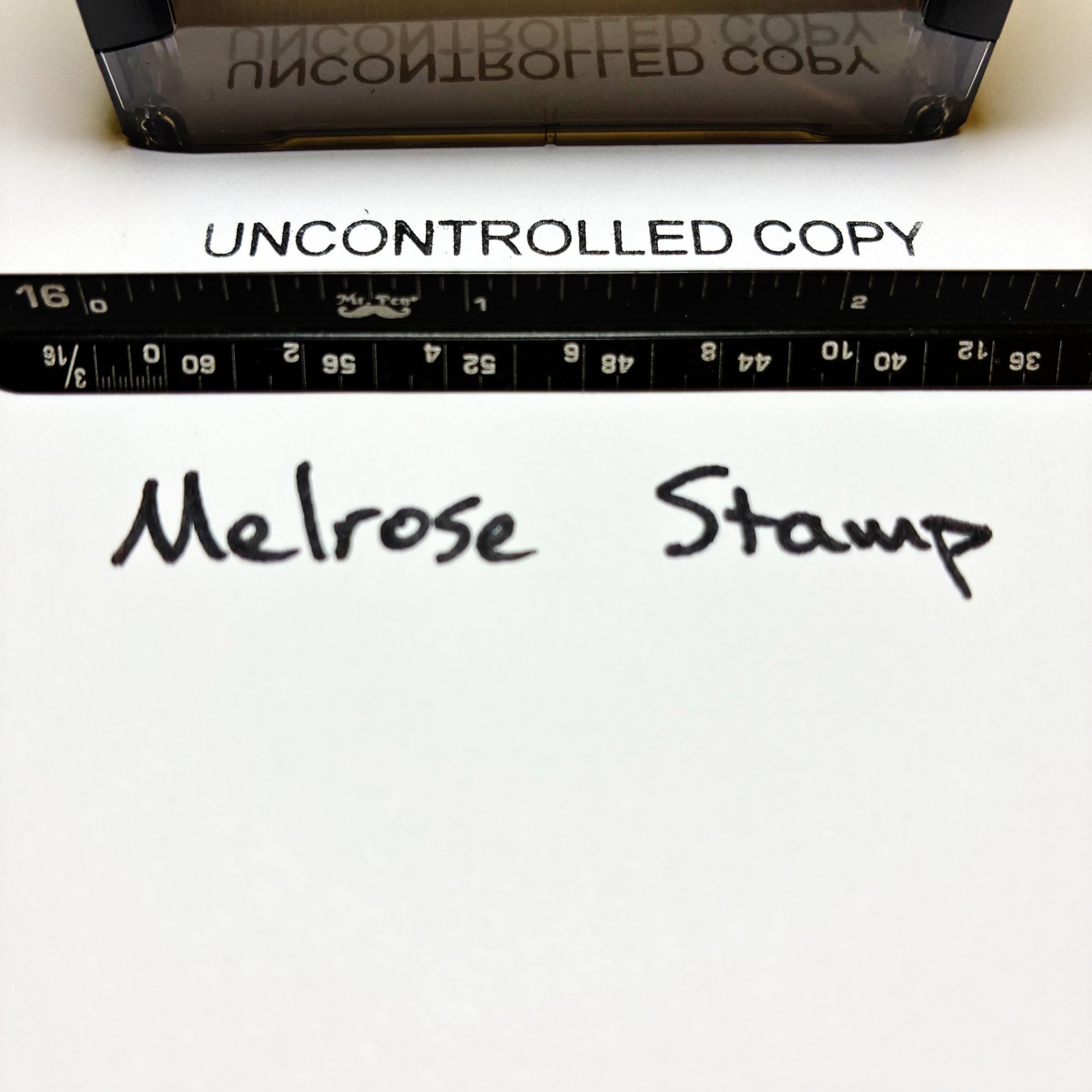 Text 'UNCONTROLLED COPY' printed on paper with a ruler and text 'Melrose Stamp'.