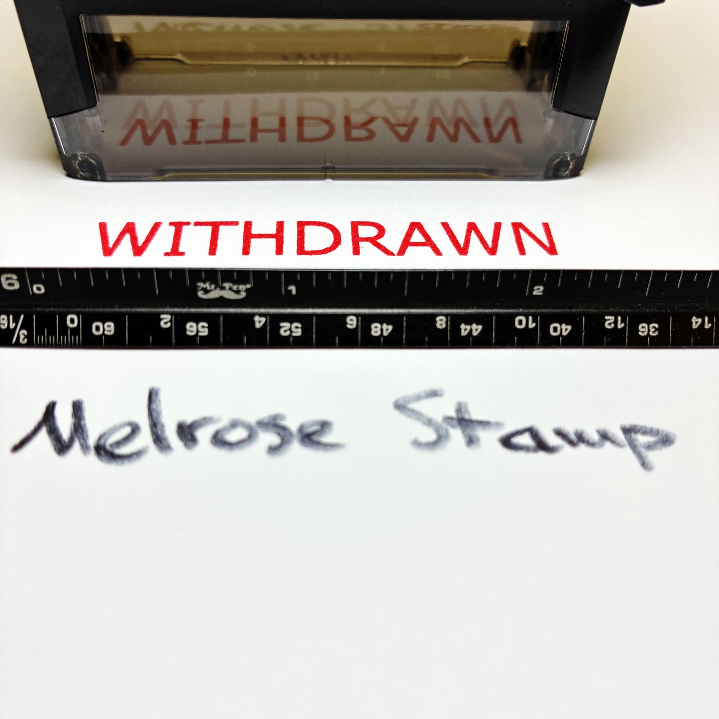 Stamp with 'WITHDRAWN' text and a ruler below, on a white background.